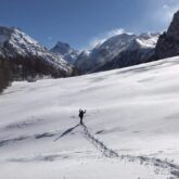 Randonneur au sein de la montagne sur un sentier tracé dans la neige en raquettes lors d'un séjour accompagné d'un guide dans le massif du Queyras