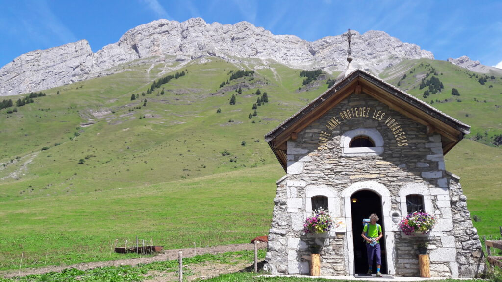 Paysage de montagne avec en fond des sommets et un bâtiment religieux