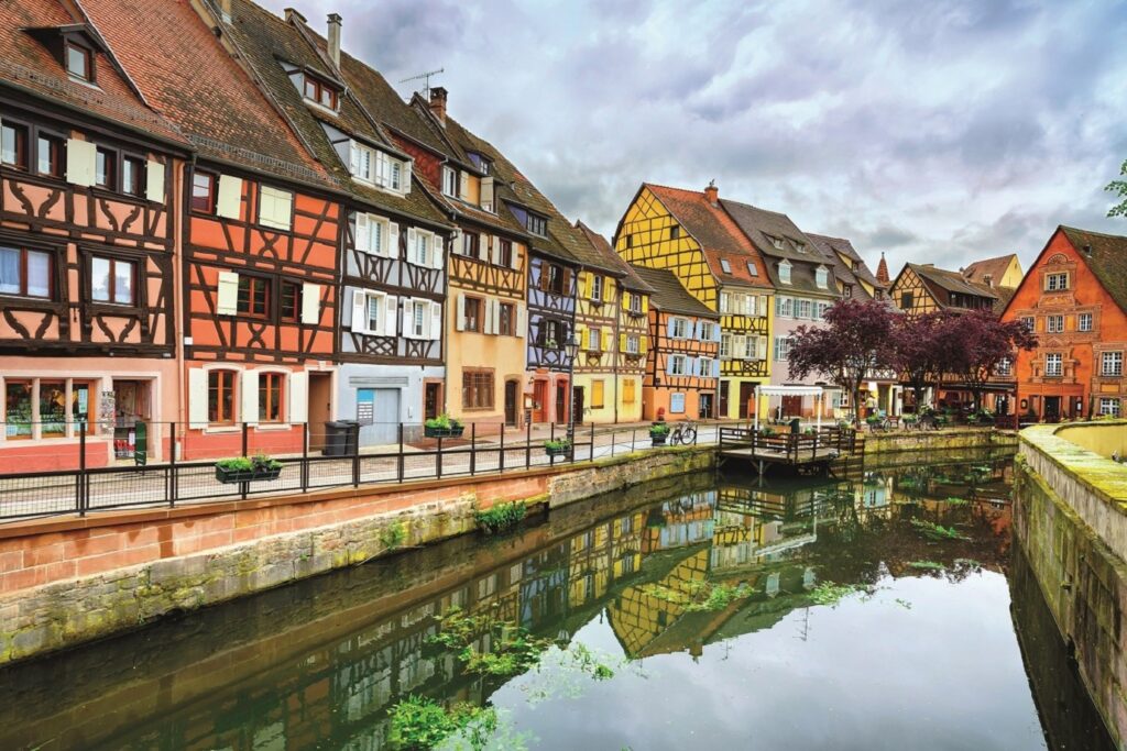 Paysage alsacien d'une ville avec des maisons à colombages qui bordent un passage d'eau
