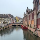Maison typique alsacienne avec des colombages qui bordent un cours d'eau