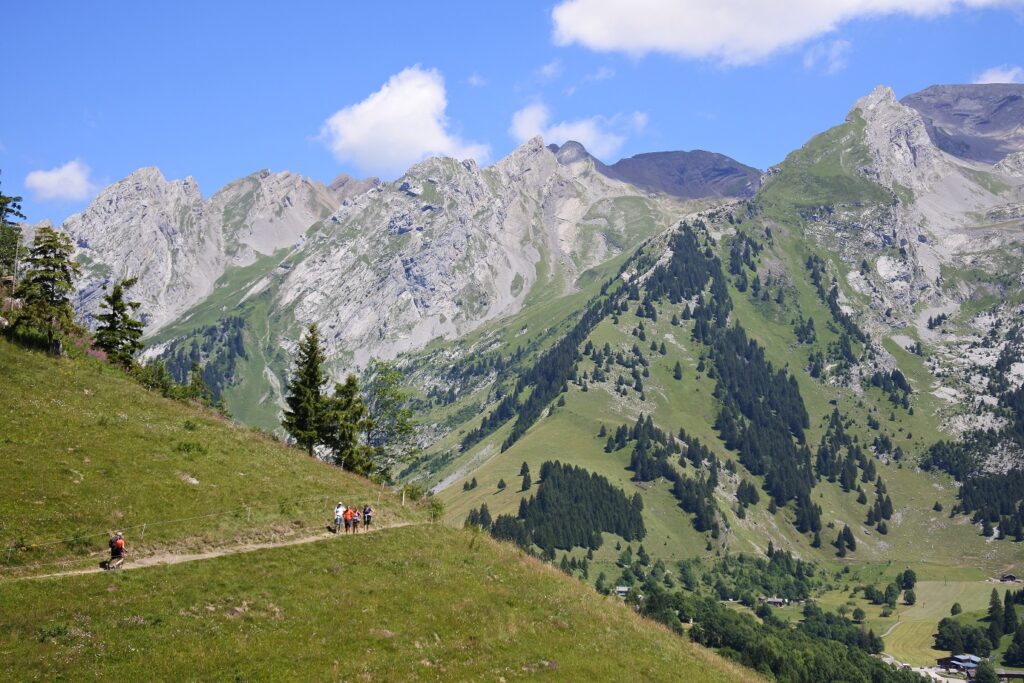 Groupe de randonneurs sur un sentier à flanc de montagne dans les Aravis