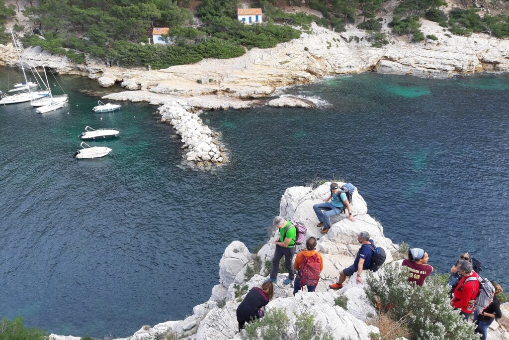 Groupe de randonneurs avec leur guide en train d'observer de haut la mer et le port
