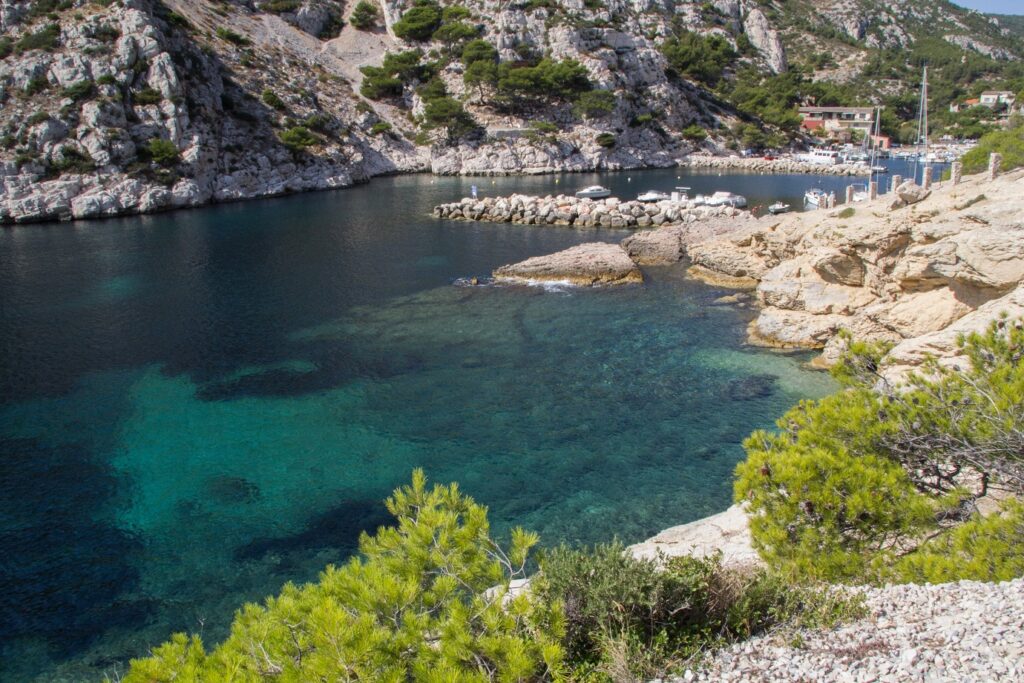 Paysage de bord de mer avec des rochers et de l'eau turquoise, encadré de falaises
