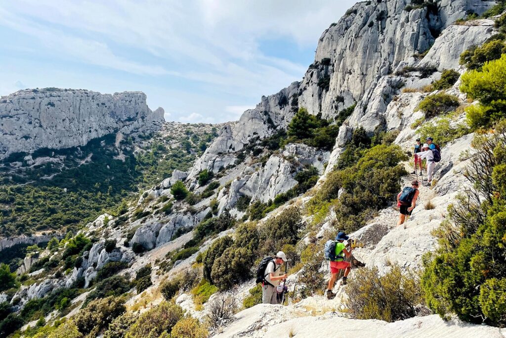 Groupe de randonneurs sur un sentier de randonnée en liberté dans les falaises et les pics de montagnes surplombant la mer