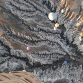 Paysage pris de vue depuis une montgolfière avec une vue de dessus de sommets et des montgolfières