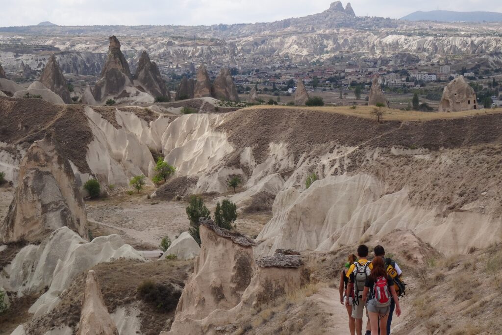 Groupe de randonneurs sur un sentier de randonnée en Turquie au sein de la Cappadoce avec différents reliefs en fond