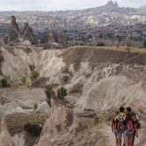Groupe de randonneurs sur un sentier de randonnée en Turquie au sein de la Cappadoce avec différents reliefs en fond