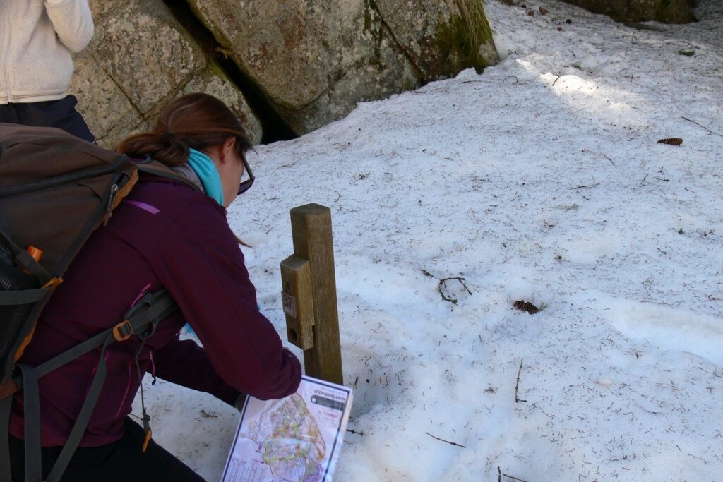 Jeune fille en train de faire une course d'orientation et de trouver une première balise dans la neige en Cerdagne