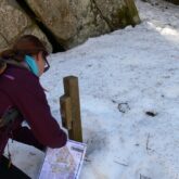 Jeune fille en train de faire une course d'orientation et de trouver une première balise dans la neige en Cerdagne