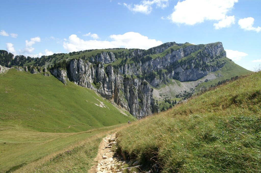 Paysage de montagne avec un sentier de randonnée et en fond des sommets dans le parc de la Chartreuse