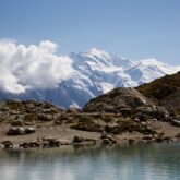 Paysage de montagne avec un lac au premier plan et à l'arrière-plan des sommets enneigés et le glacier
