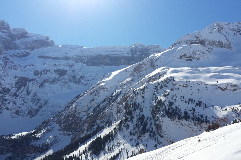 Paysage de montagne dans les Pyrénées entre Gavarnie et Cauterets, avec des sommets en fond, un paysage ensoleillé.