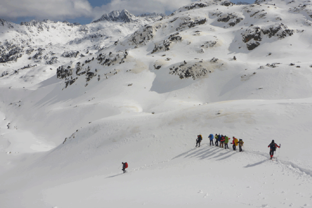 Groupe de randonneurs sur un sentier en raquettes dans les encantats