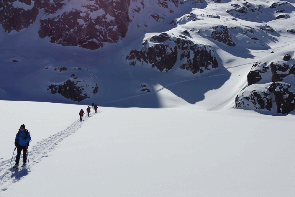 Groupe de randonneurs sur un sentier de randonnée tracé à travers la neige dans les encantats