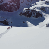 Groupe de randonneurs sur un sentier de randonnée tracé à travers la neige dans les encantats