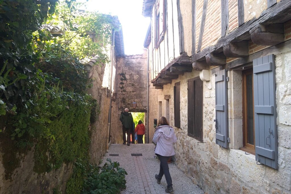Groupe de randonneurs sur un chemin dans un village du Gers lors d'un séjour de découverte du patrimoine et de la gastronomie de la zone