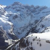 Paysage de montagne avec des sommets et des vallées couverts de neige, avec en fond des sommets