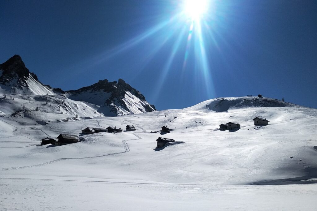 Paysage de montagne dans le Queyras sous un grand soleil en hiver, avec un espace complètement enneigé