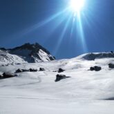 Paysage de montagne dans le Queyras sous un grand soleil en hiver, avec un espace complètement enneigé