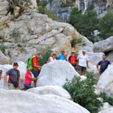 Groupe de randonneurs sur un sentier à travers des rochers blancs en bord de mer en Sardaigne