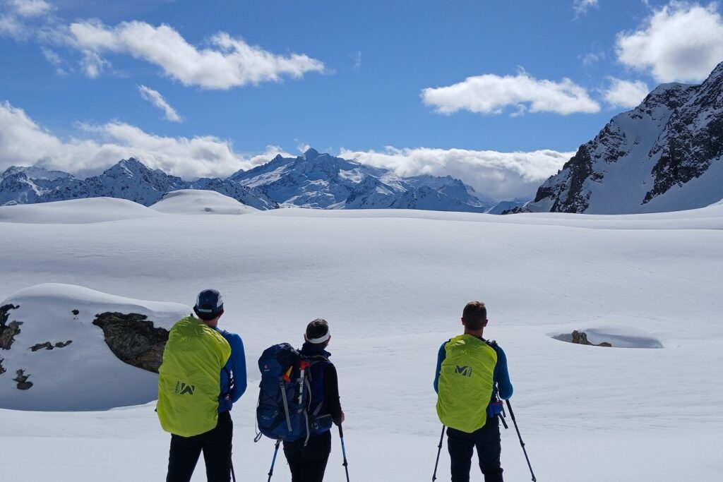 Groupe de randonneurs en raquettes avec leur guide face aux montagnes enneigées du massif du Néouvielle.