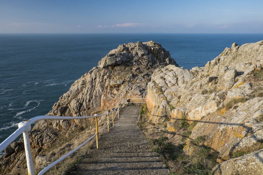 Paysage sur des îles au large de la Bretagne d'un escalier qui descend au sein des roches vers l'océan