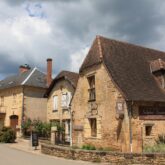 Paysage d'un village du Périgord avec des maisons au toit typique de la région