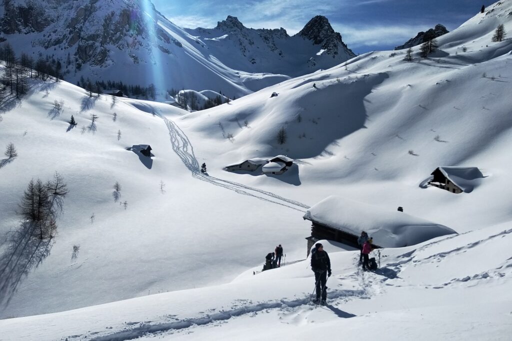 Paysage du massif du Queyras dans les Alpes sous un grand soleil en hiver observé lors d'un séjour de randonnée en raquettes en gîte