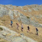 Groupe de randonneurs sur un sentier avec leur guide dans le haut Verdon entouré d'un paysage montagnard