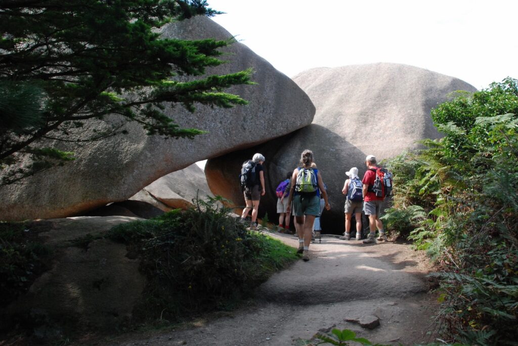 Groupe de randonneurs sur un sentier avec leur guide face a des rochers