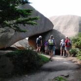 Groupe de randonneurs sur un sentier avec leur guide face a des rochers