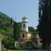 Paysage d'un village en Italie proche du lac de Côme avec vue sur l'église de ce village encadrée de cyprès