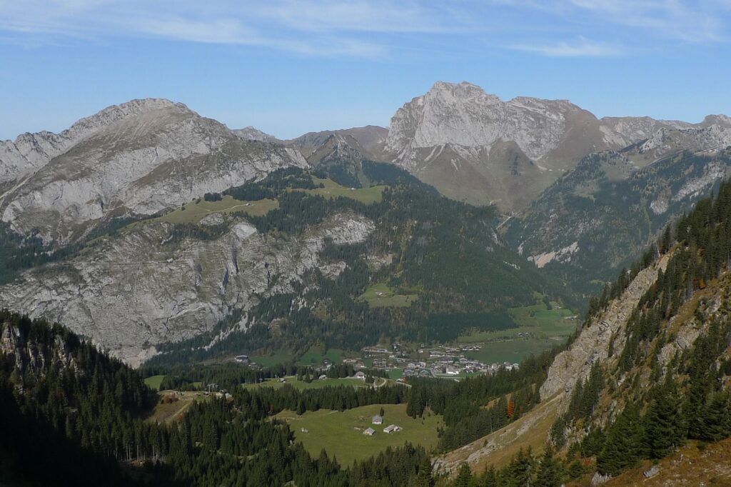 Paysage de montagne avec des montagnes de part et d'autre qui donnent sur une vallée, avec un village en contrebas
