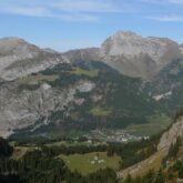 Paysage de montagne avec des montagnes de part et d'autre qui donnent sur une vallée, avec un village en contrebas