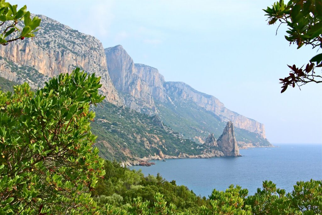 Paysage de bord de mer avec sur la gauche des falaises et de la végétation et sur la droite la mer, en Sardaigne