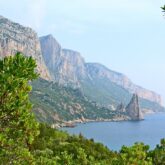 Paysage de bord de mer avec sur la gauche des falaises et de la végétation et sur la droite la mer, en Sardaigne