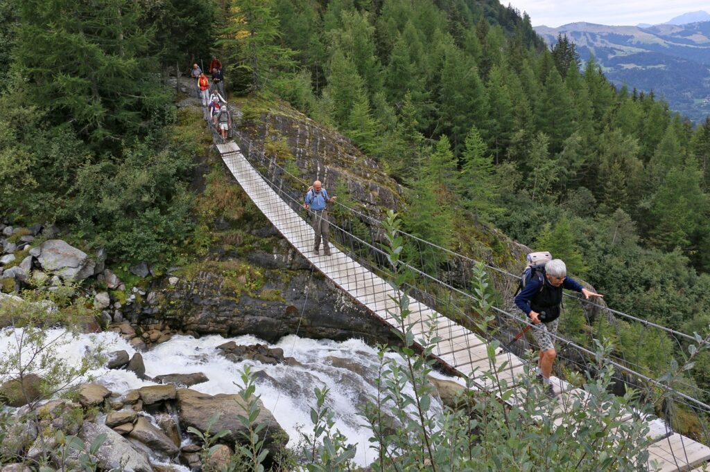 Groupe de randonneurs sur une passerelle en montagne lors du tour du mont Blanc Nord