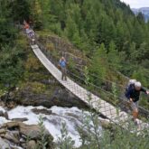Groupe de randonneurs sur une passerelle en montagne lors du tour du mont Blanc Nord