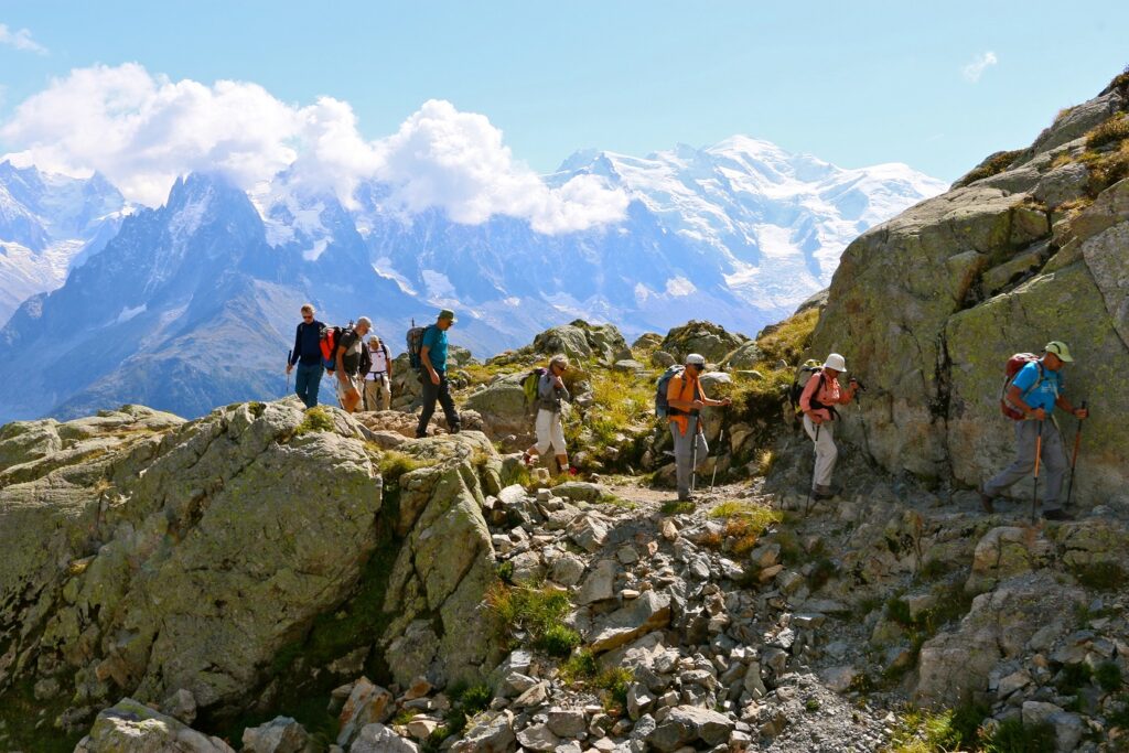 Groupe de randonneurs sur un sentier encadré de part et d'autre de roches