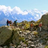 Groupe de randonneurs sur un sentier encadré de part et d'autre de roches