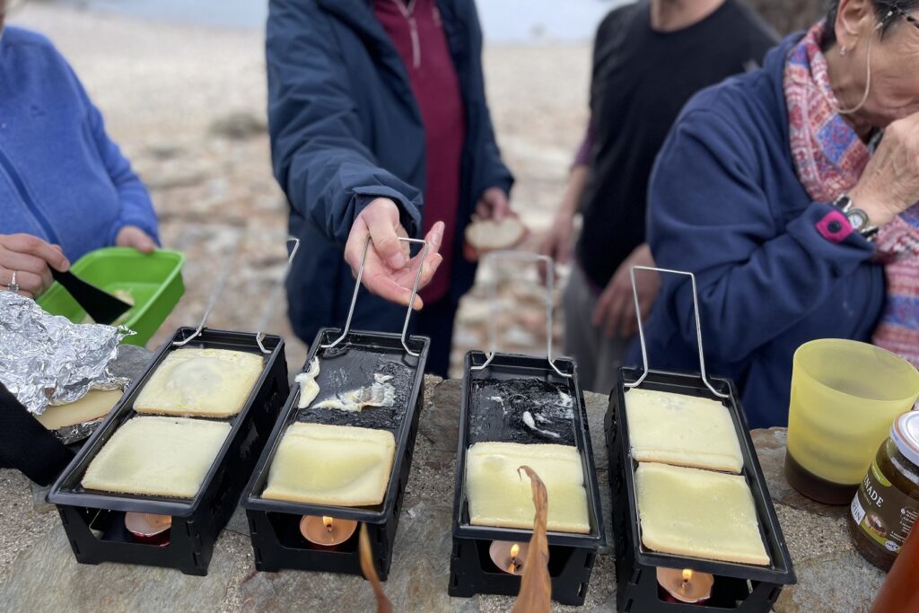Randonneurs en train de faire une raclette en bord de mer