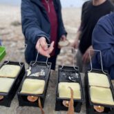 Randonneurs en train de faire une raclette en bord de mer