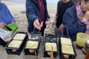Randonneurs en train de faire une raclette en bord de mer
