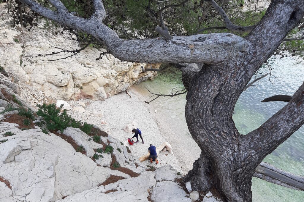 Vue de haut de deux personnes sur une plage en train de préparer un pique-nique