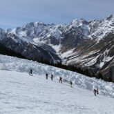 Groupe de randonneurs sur un sentier de randonnée accompagnés par leur guide en raquettes