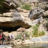 Groupe de randonneurs sur un sentier de randonnée avec leur guide, le sentier est bordé d'un point d'eau