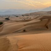 Paysage désertique avec des dunes de sable éclairé par le soleil qui se couche à Oman