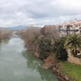 Paysage dans la ville de Pampelune avec de la végétation et un cours d'eau qui sépare les lieux