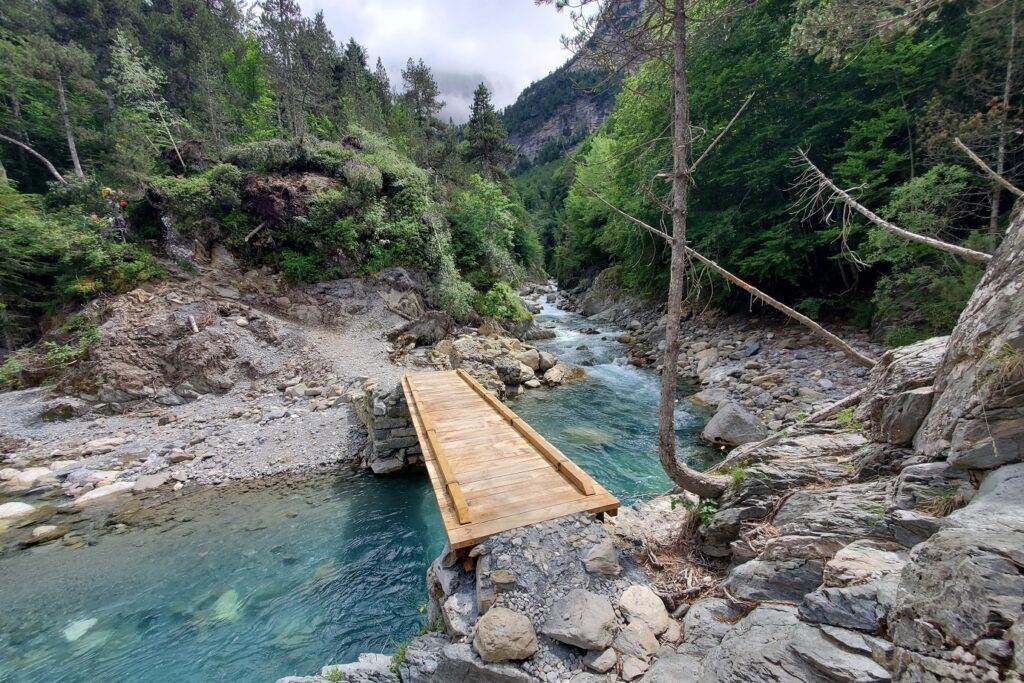 Paysage d'un ponton en bois au-dessus d'un cours d'eau, observé lors de randonnées familiales entre Gavarnie et Cauterets