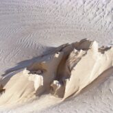 Paysage désertique avec la marque du vent sur le sable blanc